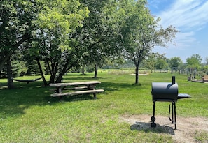 Enjoy al fresco dining in a serene park-like setting with a barbecue grill and picnic table.