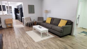 A living room with a sofa, a coffee table, and a lamp.