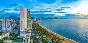 A coastal cityscape with high-rise buildings, a beach, and a clear sky. - Oceanus Oasis Retreat (Bac Nha Trang)
