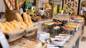 A buffet with various food items including bread, pastries, and fruits.