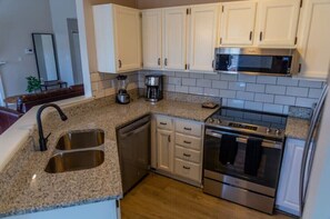 Enjoy cooking in this well-equipped kitchen with a stainless steel sink, dishwasher, coffee maker, microwave, and oven.