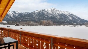 Una terraza de madera con vistas a montañas nevadas.