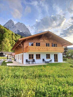 A chalet with a balcony, multiple windows, and a view of mountains. - Apartment "Bergenzian" with Mountain View, Balcony & Wi-Fi (Grainau)