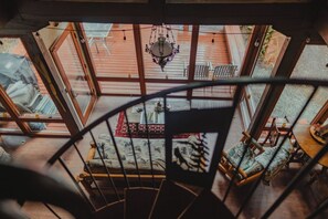 Enjoy a spacious room with a spiral staircase leading to an upper level and a patio area with a wooden deck and table.
