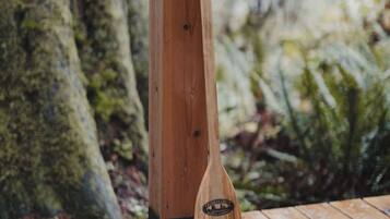 Une table en bois avec une pagaie appuyée contre un poteau en bois.