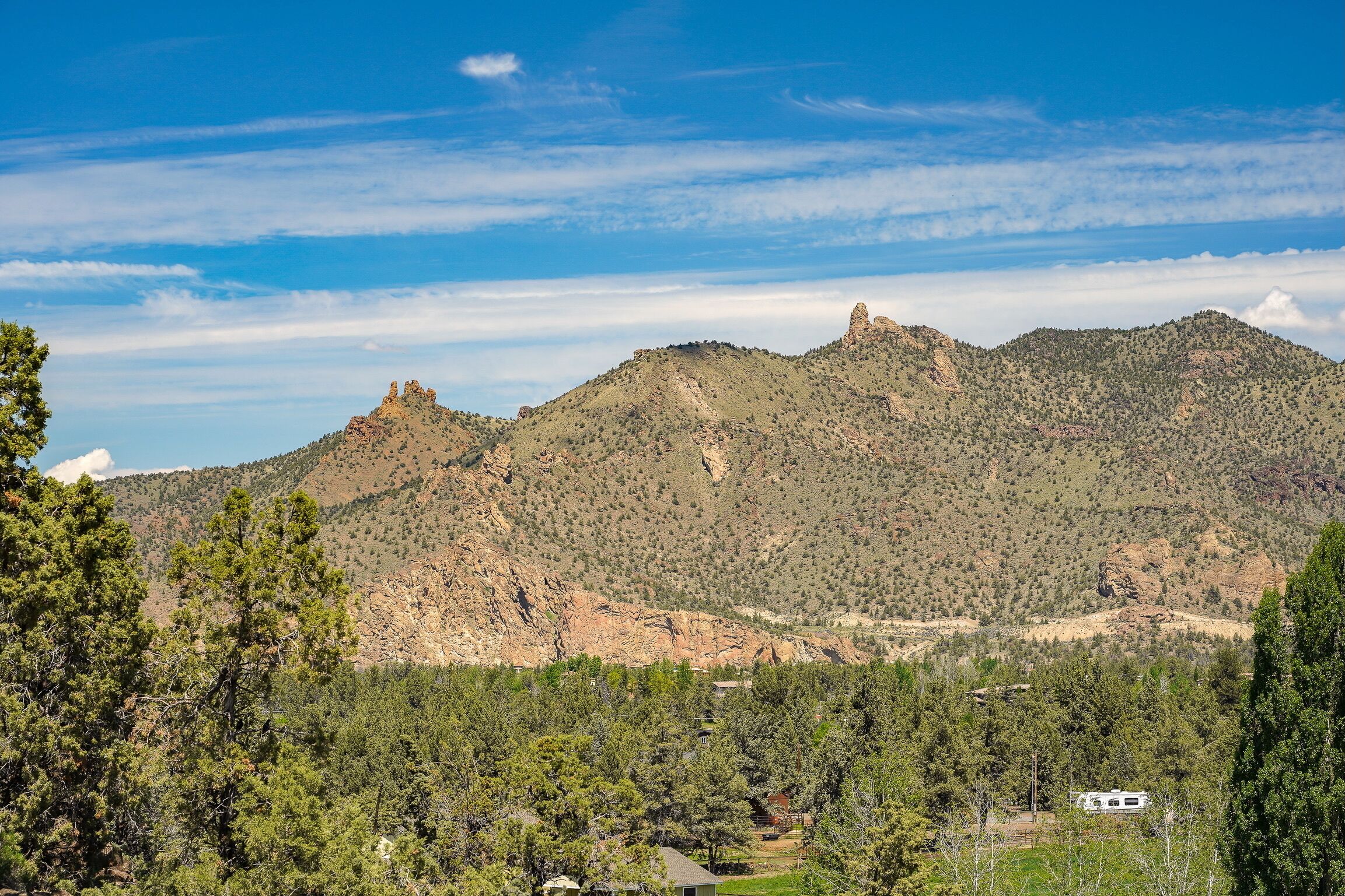 Un paisaje montañoso con una casa al frente.
