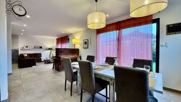 A dining area with a table set for four, chairs, and pendant lighting.