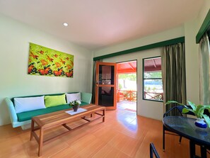 Deluxe Beachfront Suite | Zona de estar | Televisión LED de 32 pulgadas con canales por satélite, una televisión