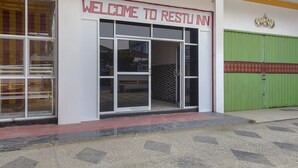 Entrada de un edificio con un cartel que dice "WELCOME TO RESTU INN".