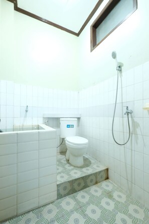 Een badkamer met een toilet, een douche en een wastafel.
