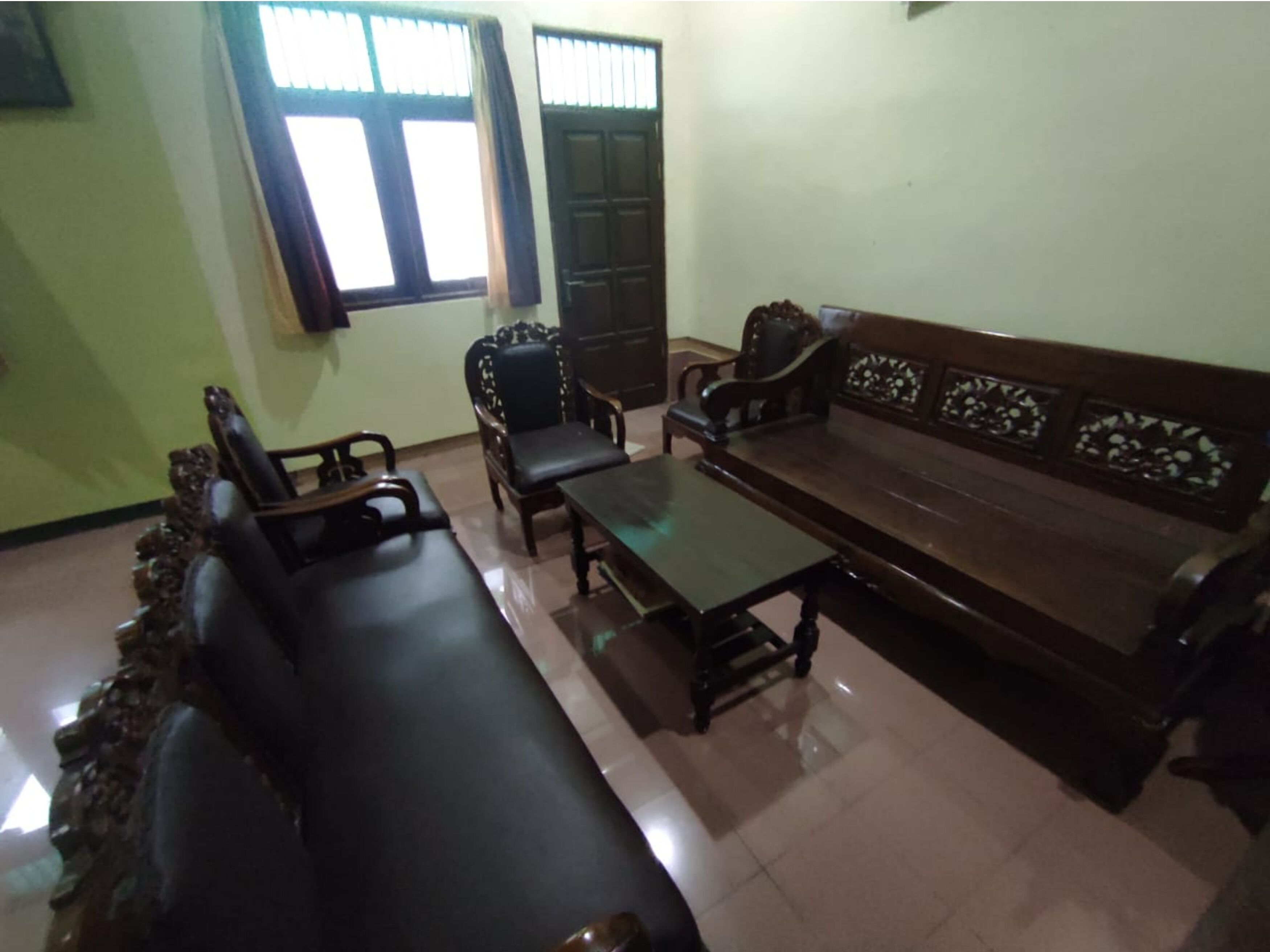 Una sala de estar con un sofá, dos sillones y una mesa de centro.