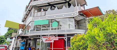 Un immeuble à plusieurs étages, doté d’une porte rouge bien visible et d’une enseigne indiquant « DUDIDU DIMSUM ».