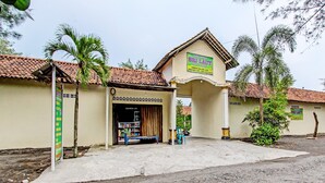 A building with a tiled roof and a sign indicating it is a Sri Laut shopping center. - Hotel O Sari Laut (Temon)