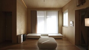 Una habitación minimalista con un ventanal grande, un banco y un radiador.