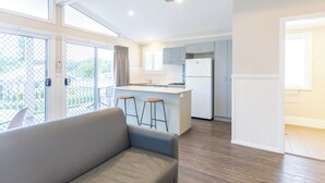 Cozinha moderna com ilha central, banquetas e geladeira.