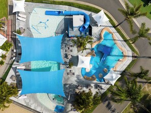 An aerial view of a water park with multiple pools, slides, and sun loungers. - NRMA Forster Tuncurry Holiday Park (Tuncurry)