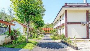 Un camino que lleva a un edificio con varios balcones y unidades de aire acondicionado.