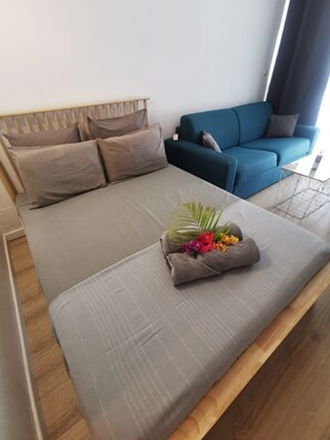 Un dormitorio moderno con una cama, un sofá azul y una mesita.