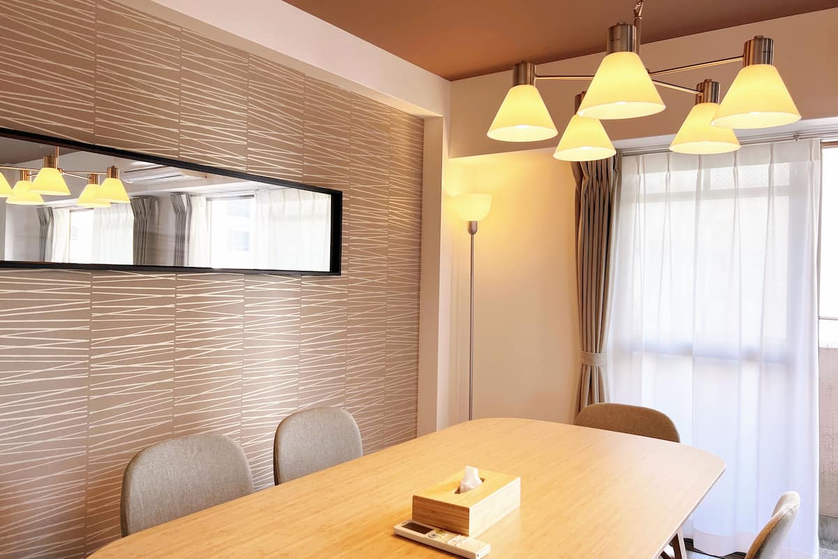 Ein modernes Hotelzimmer mit einem Holztisch für Konferenzen, einer Taschentuchbox und einer Stehlampe.