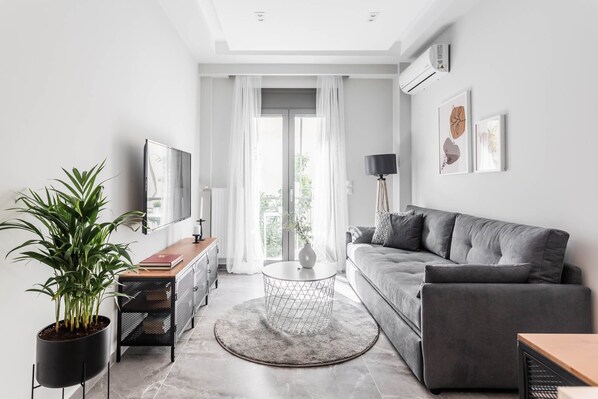 Relax in this stylish living room with a sofa, coffee table, and flat-screen TV.