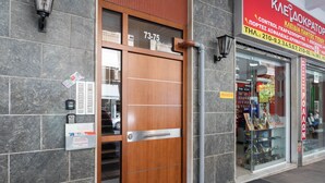 Fachada moderna de un edificio con puerta de madera, ventana de cristal y marco de metal.