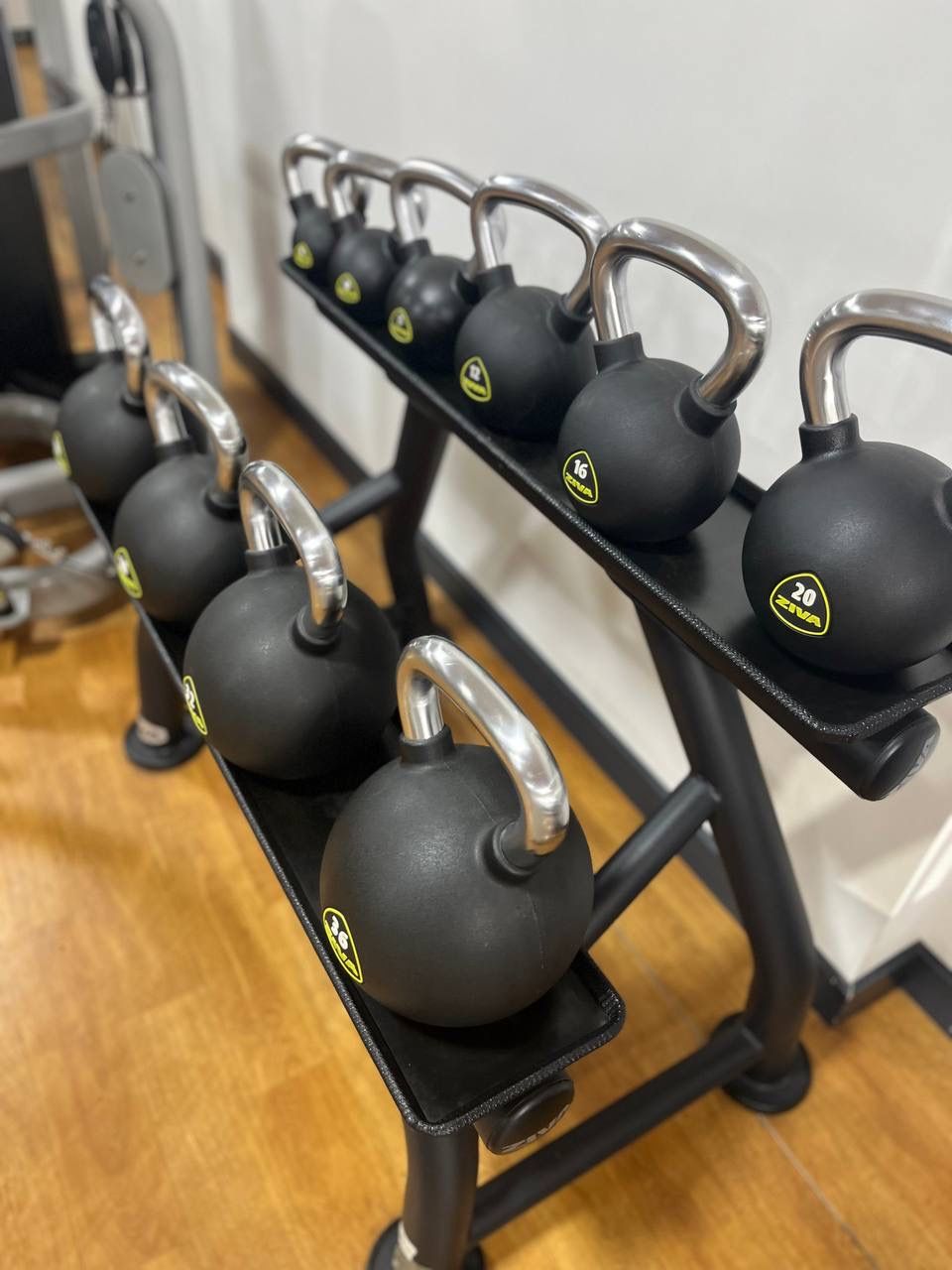 A rack of kettlebells with weight markings.