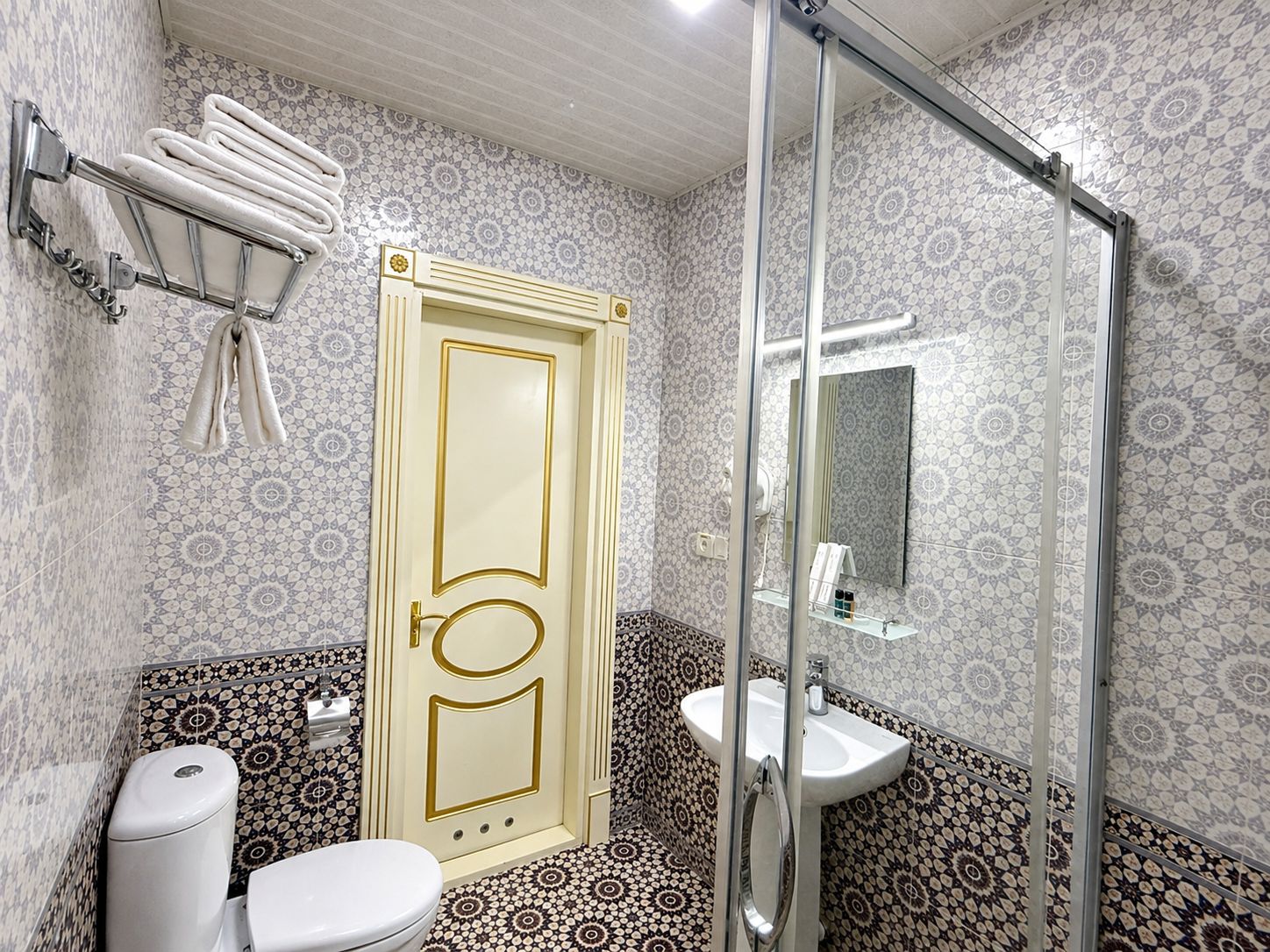 A bathroom with a toilet, sink, and shower.