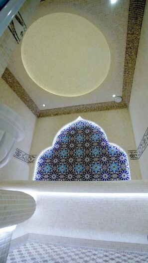 A view of a room with a patterned ceiling, a decorative arch, and a patterned window. - VELARA HOTEL (Tashkent)