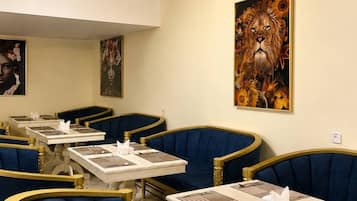 A restaurant interior with booths, tables, and artwork on the walls.