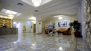 Un hall d’hôtel comprenant un comptoir d’accueil, un espace salon et des éléments de décoration.