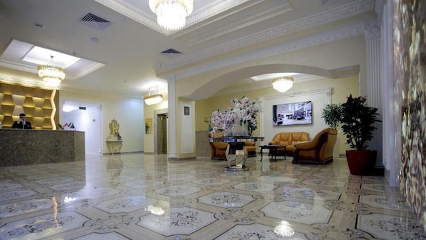 Eine Hotelhalle mit Empfangsschalter, Sitzgelegenheiten und Dekorationselementen.