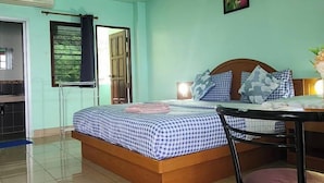 A room with a bed, a table, and a chair. There is a window and a door. - PAILIN HILL (Patong)