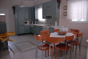 Kitchen area with dining table for six, microwave, sink, and range hood.