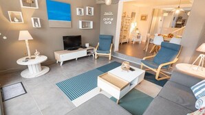A modern living room with a flat-screen TV, a coffee table, and seating area.