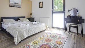 A bedroom with a bed, a dresser, a mirror, and a window. - Villa Miarritze - Welkeys (Biarritz)