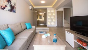 A modern living room with a sofa, coffee table, and TV. - Enali Villas-Villa Artemi (Κίσσαμος)