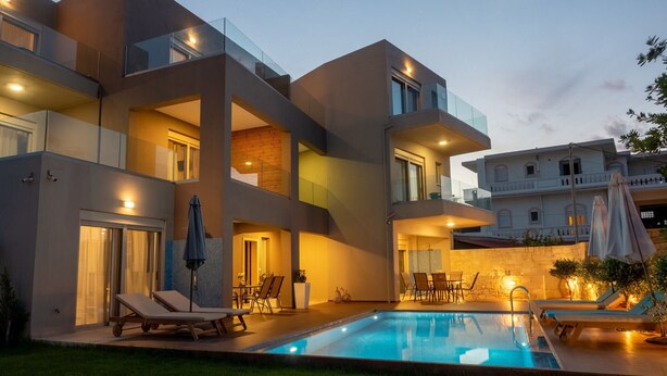 A modern multi-story building with a swimming pool, outdoor seating, and a balcony. - Enali Villas-Villa Artemi (Κίσσαμος)