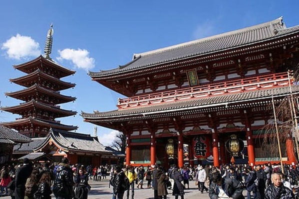 Un tempio tradizionale giapponese con diversi tetti a pagoda e un grande portale rosso.