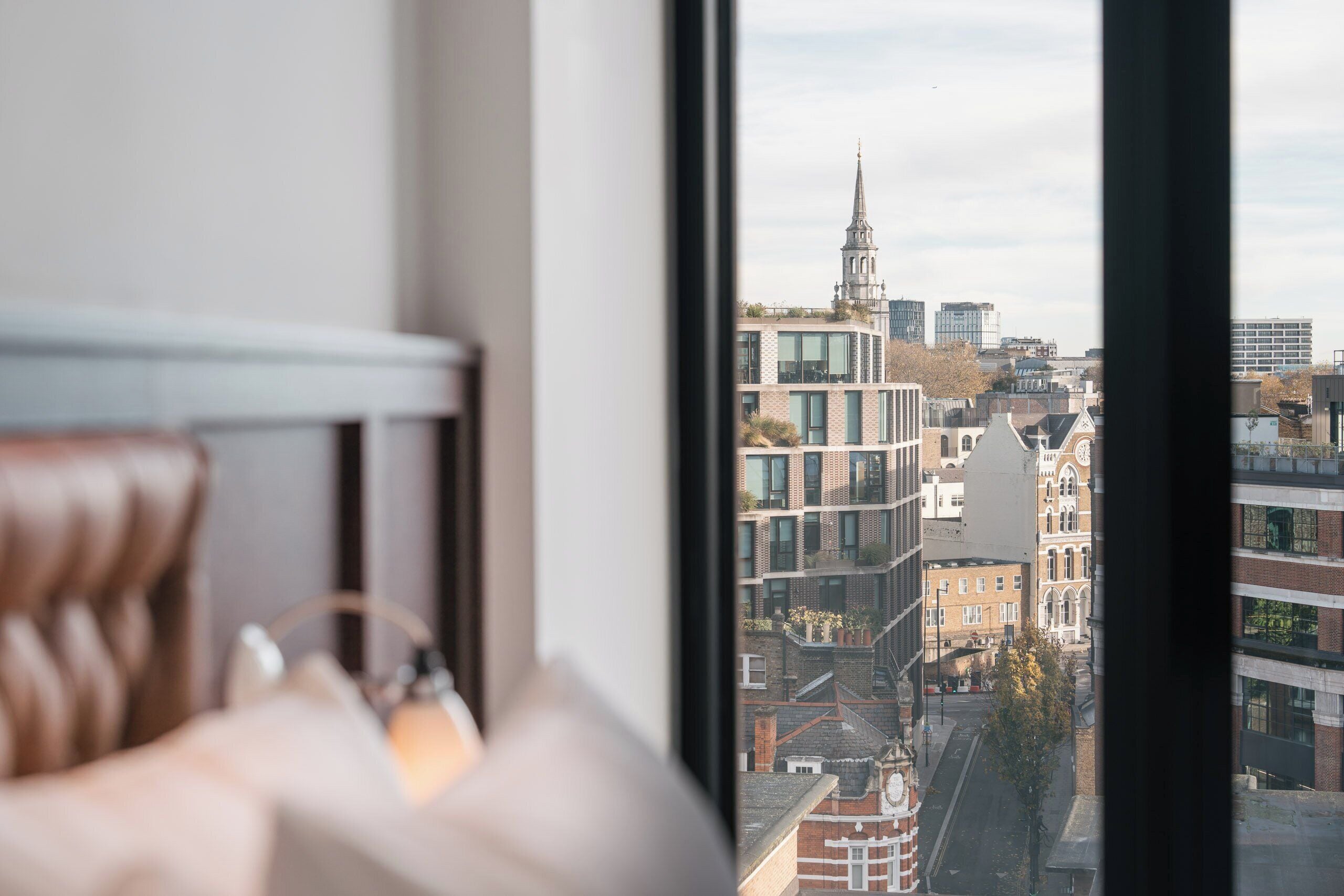 Una stanza con vista sulla città, tra cui un campanile e palazzi moderni.
