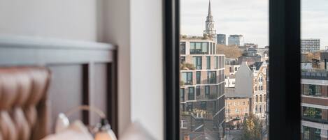 Una stanza con vista sulla città, tra cui un campanile e palazzi moderni.