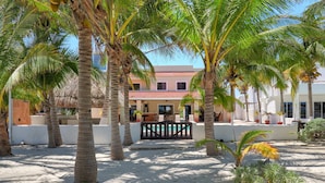 Un resort con palmeras, piscina y un edificio de techo rojo.