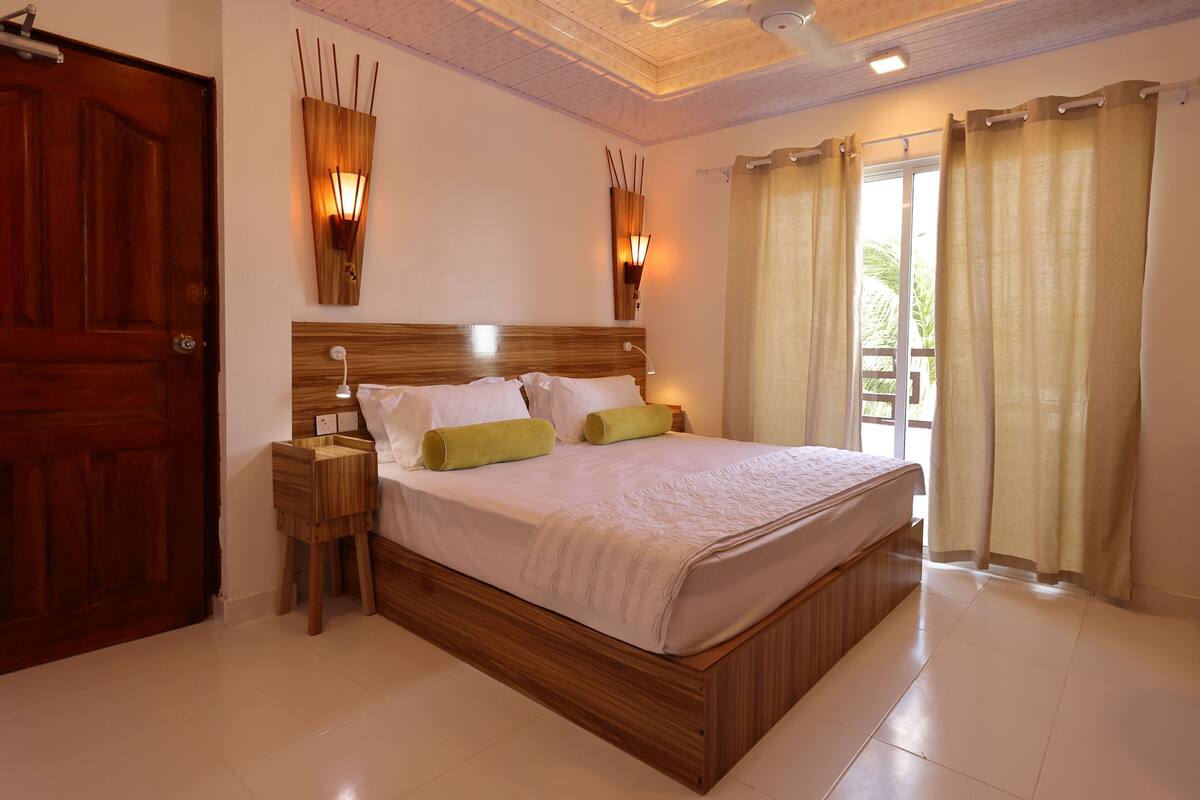 Un dormitorio con cama de madera, mesitas de noche e iluminación empotrada.