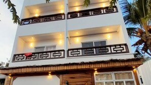 A two-story building with a wooden entrance and multiple balconies.