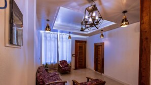 A spacious living area with a high ceiling, a skylight, and a modern chandelier.