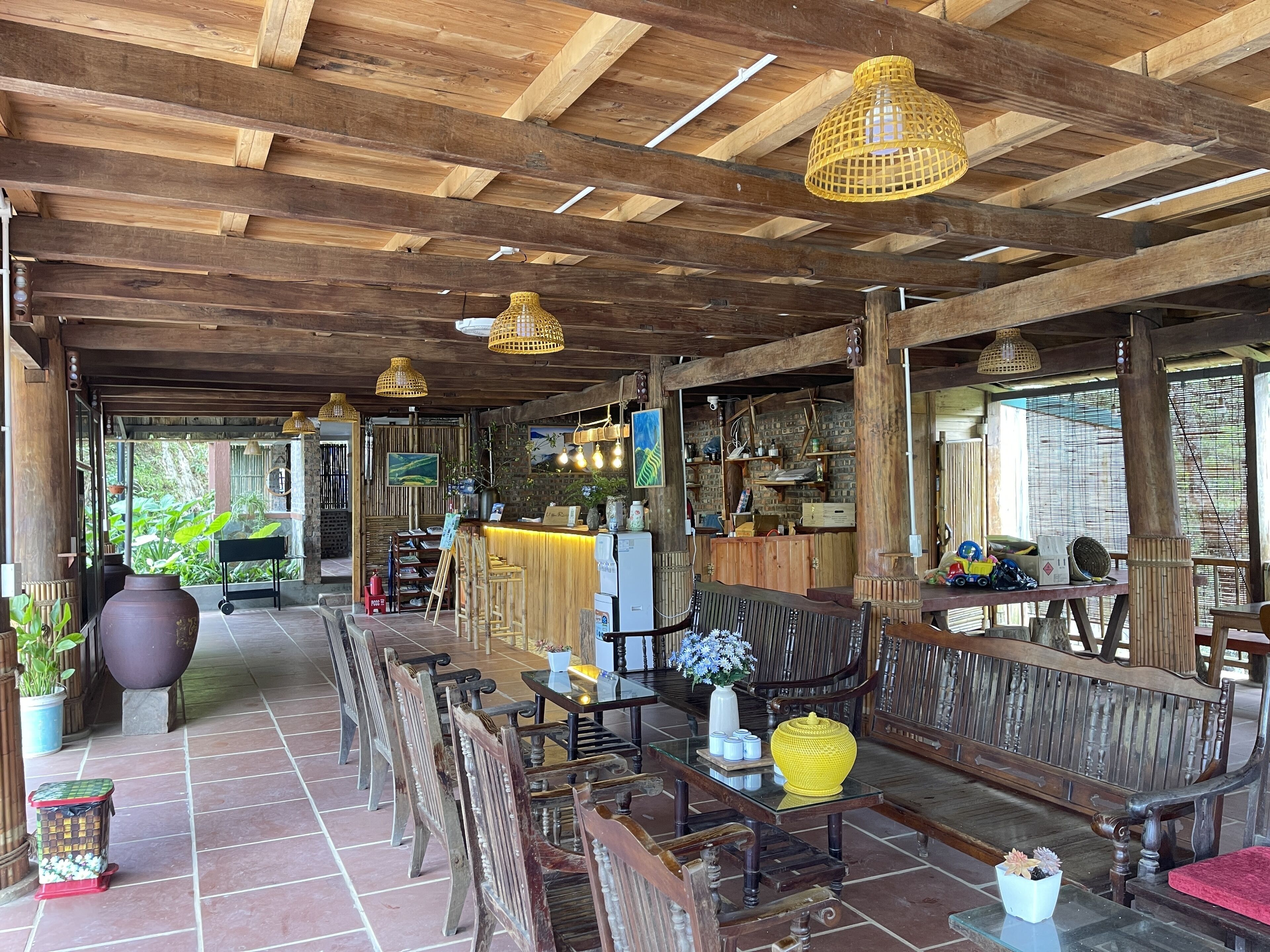 A rustic wooden interior with exposed beams, a bar area, and seating arrangements.