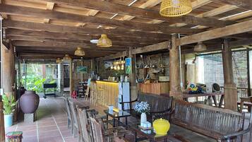 A rustic wooden interior with exposed beams, a bar area, and seating arrangements.