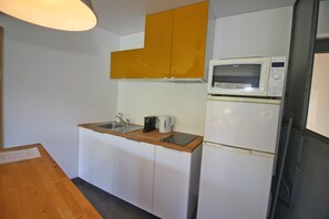 A small kitchen with a microwave, a kettle, and a sink. - Apartment with Private Beach in Gerês (Gerês)