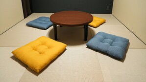 Uma mesa redonda de madeira com quatro almofadas quadradas em tons de amarelo e azul.