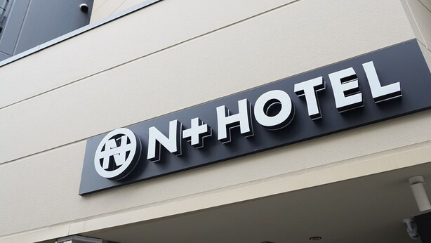 Placa de hotel com o nome 'N+HOTEL' e um logotipo.