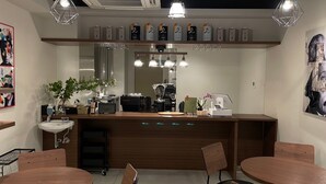 Uma área de bar moderna com balcão, assentos e uma máquina de café.